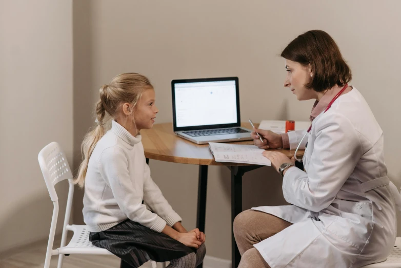 two young female doctors having a conversation on the computer