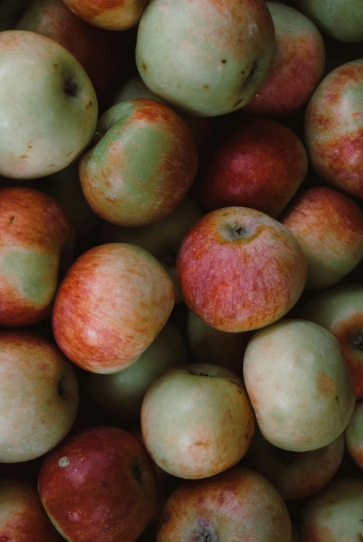 a pile of apples is shown with red and white spots