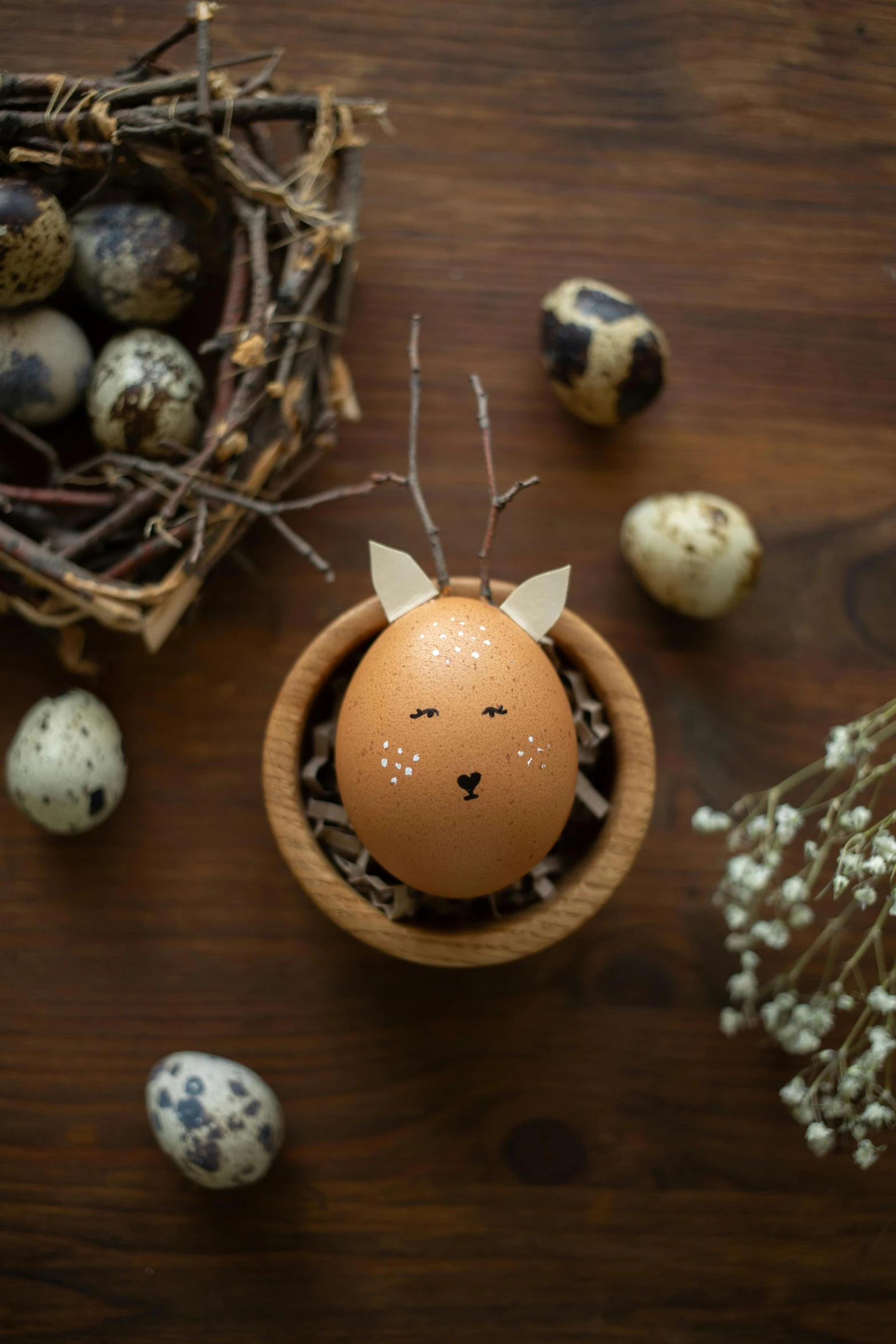 a small wooden bird nest with eggs near by