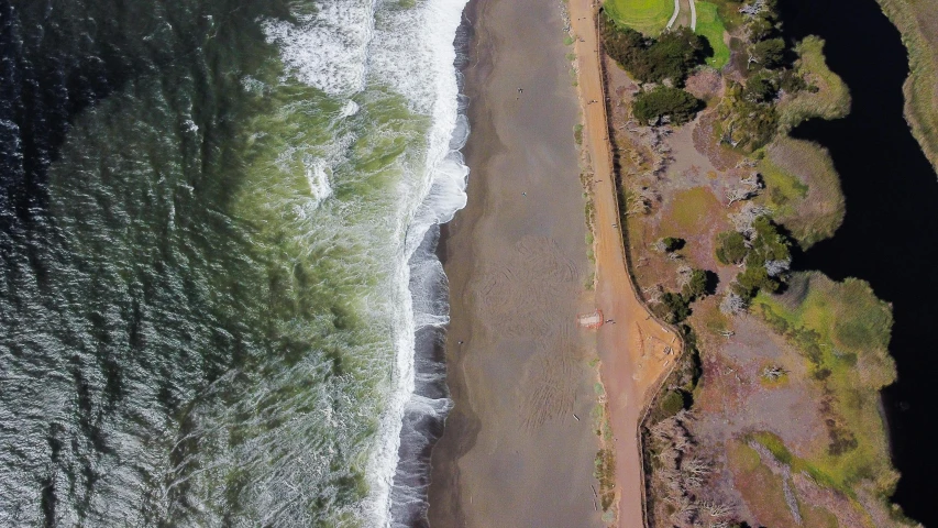 an aerial s of a beach with waves crashing into it