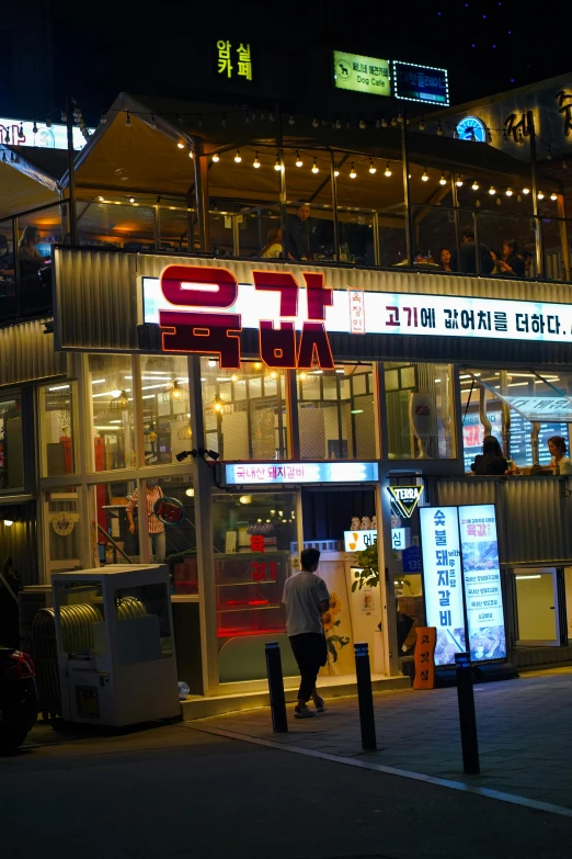 the store has lit up neon signs in a foreign language