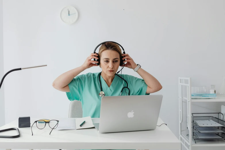 a person wearing headphones sitting in front of a laptop