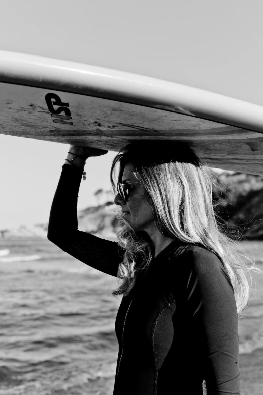 a woman with sunglasses and a surfboard on her head