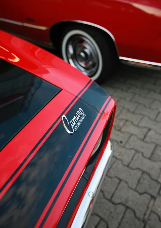 a red and black car parked on the side of a road