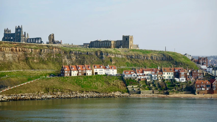 a city on top of a hill next to a body of water