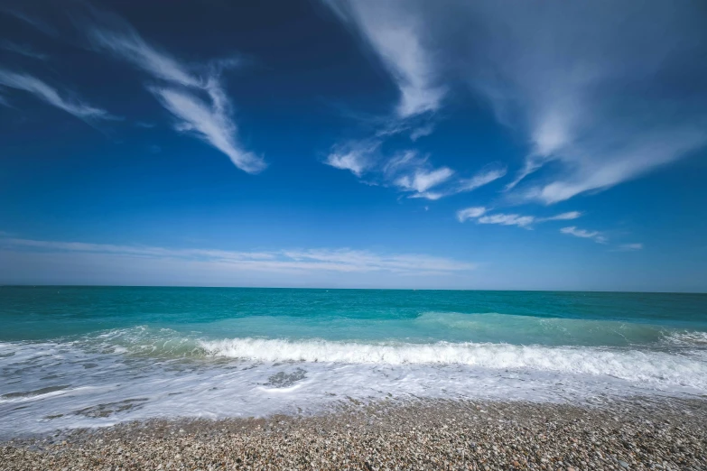 an ocean with a wave crashing on it and another body of water in the distance