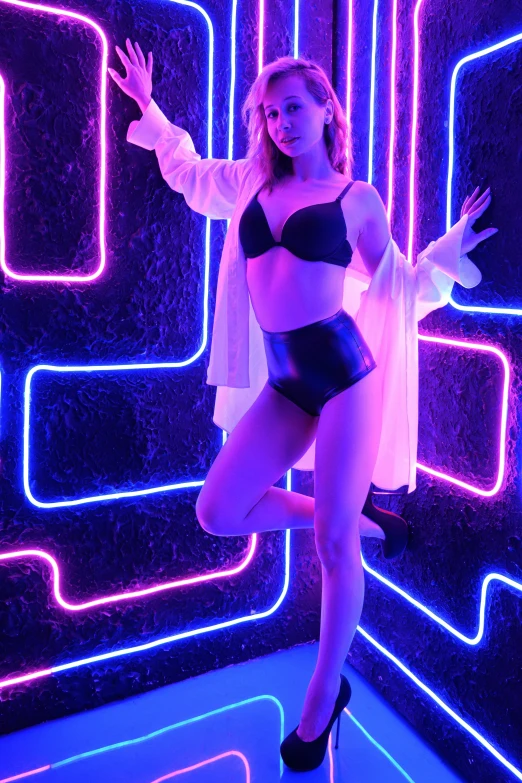 a girl with an outfit on is standing in front of neon light