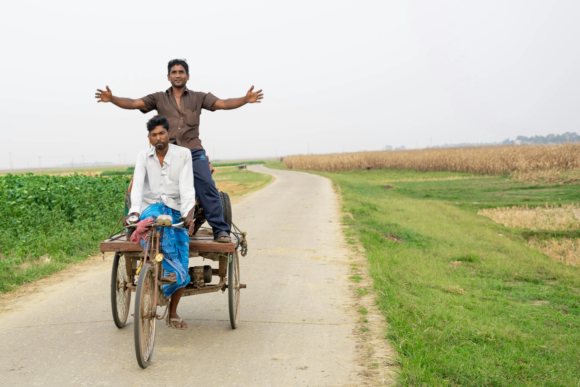 a man standing on top of two people on a bike