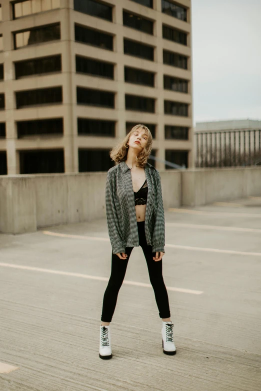 a young woman stands in a parking lot