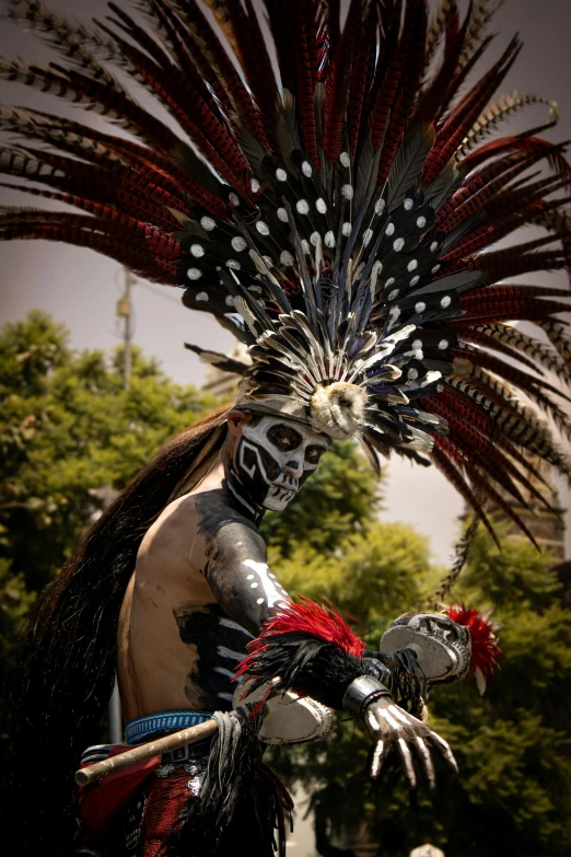 a man wearing a mask and colorful feathers in his head