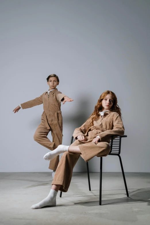 two people in brown and white clothing standing and sitting