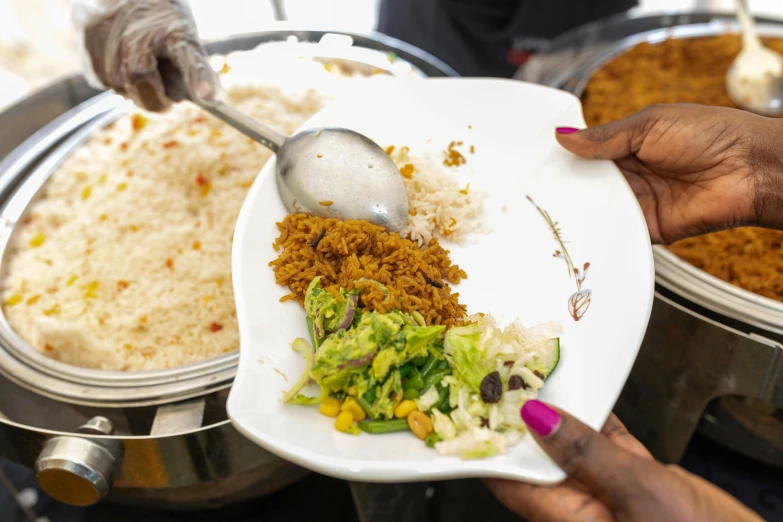 someone spooning food out of a plate on a white plate