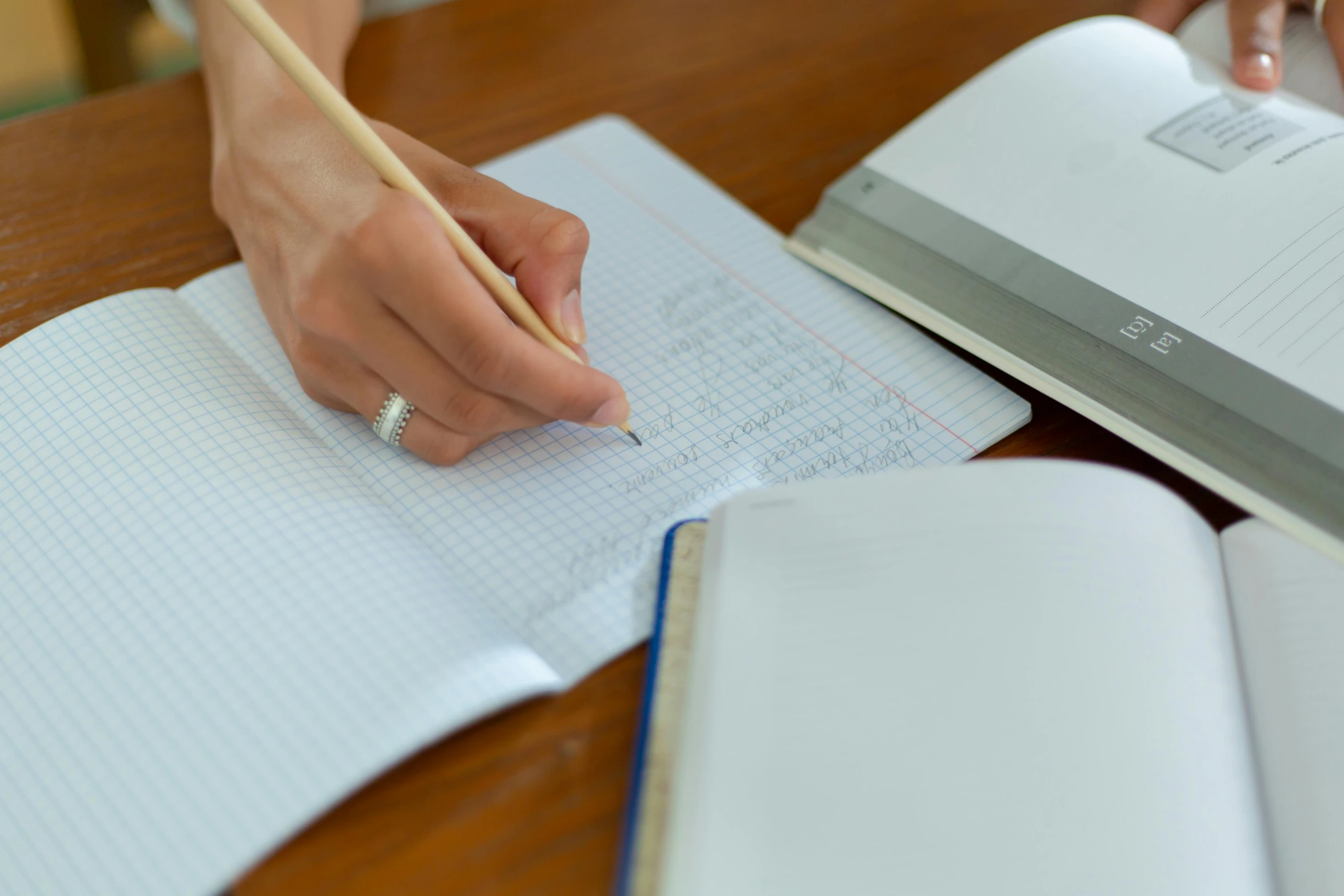 someone holding a pencil on top of a note pad