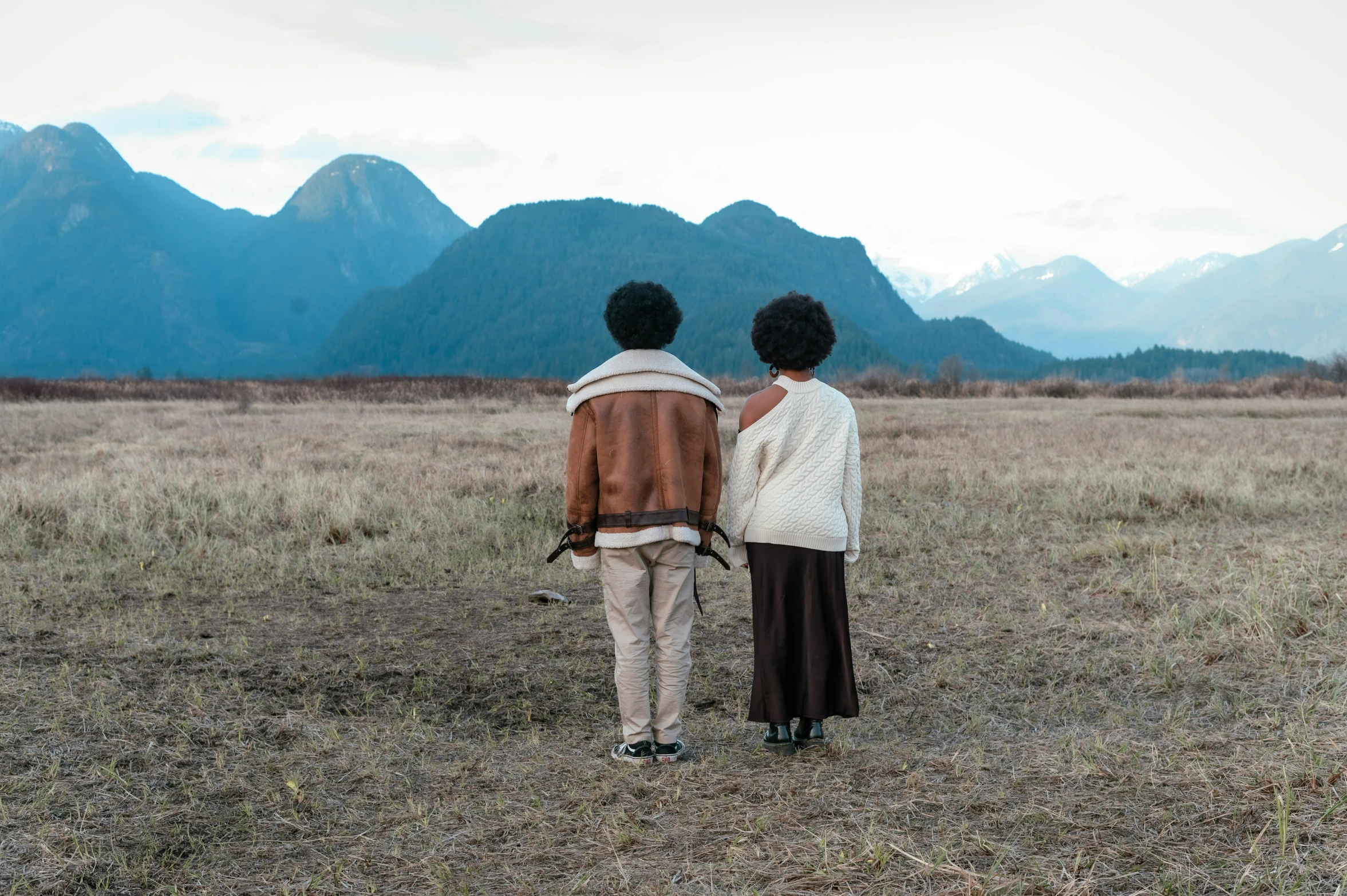 two women are standing in a field together