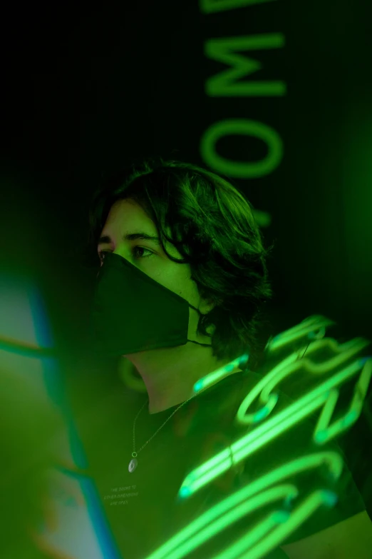 a beautiful young lady holding a green neon sign