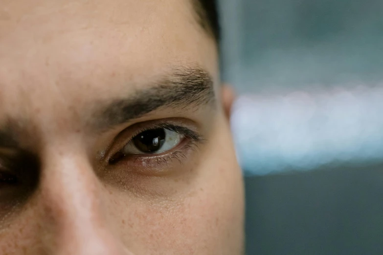 a close up of a mans eye with blurry background