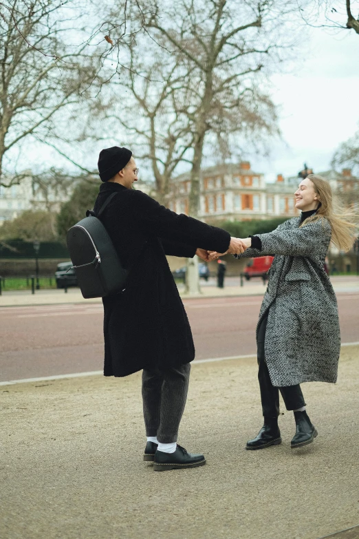 a man and woman are facing each other as one woman holds the arm of the other person