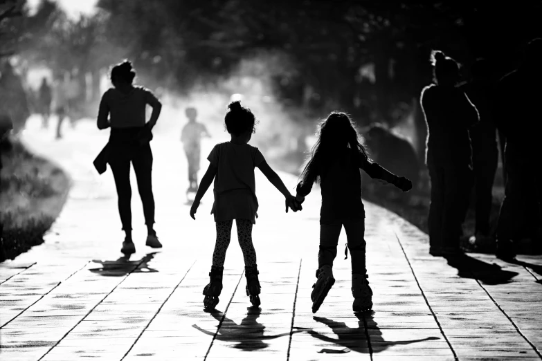 two s are holding hands as they walk down a sidewalk