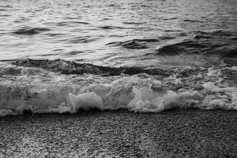 waves come in on the beach sand with an umbrella