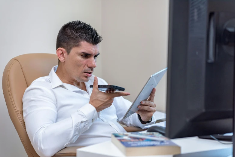 a man using a tablet on his desk