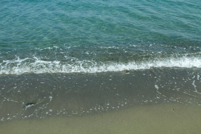 the ocean waves are coming in towards a shoreline