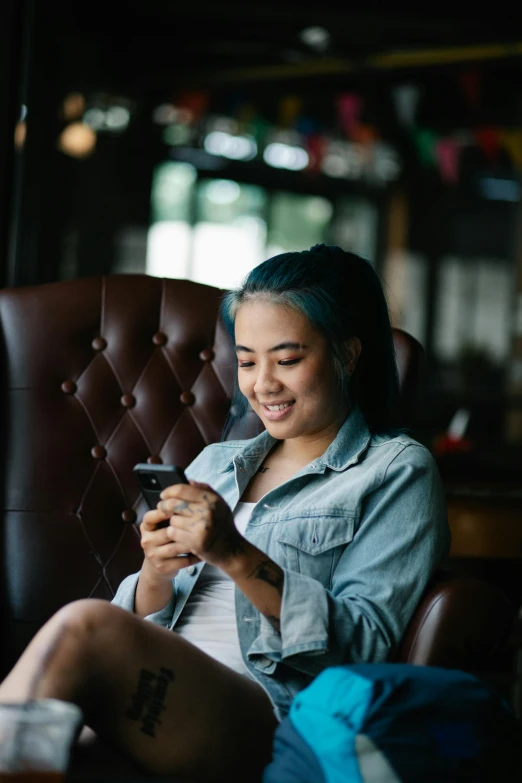 a woman on a brown chair looking at her phone