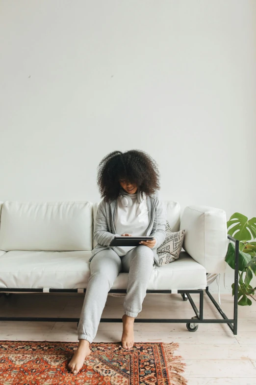 a woman using her ipad on a couch