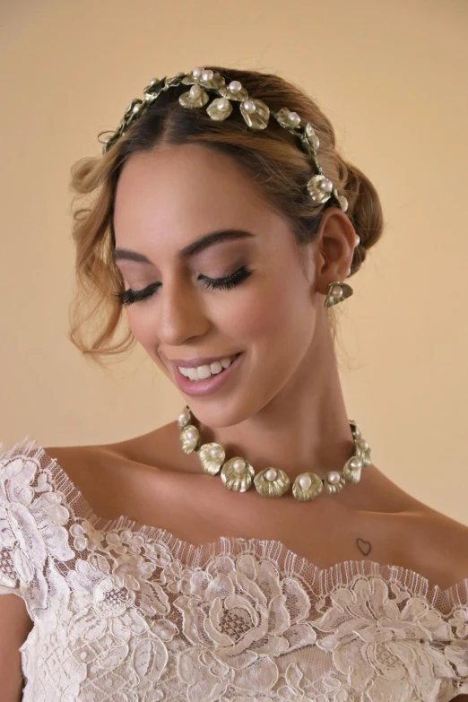 a smiling woman in a dress with a gold wreath on her head