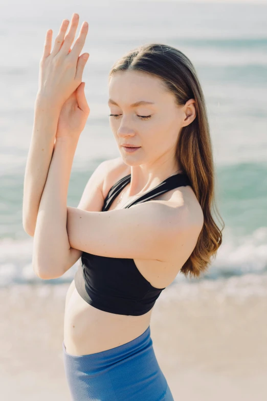 the woman is wearing her arms apart and doing yoga