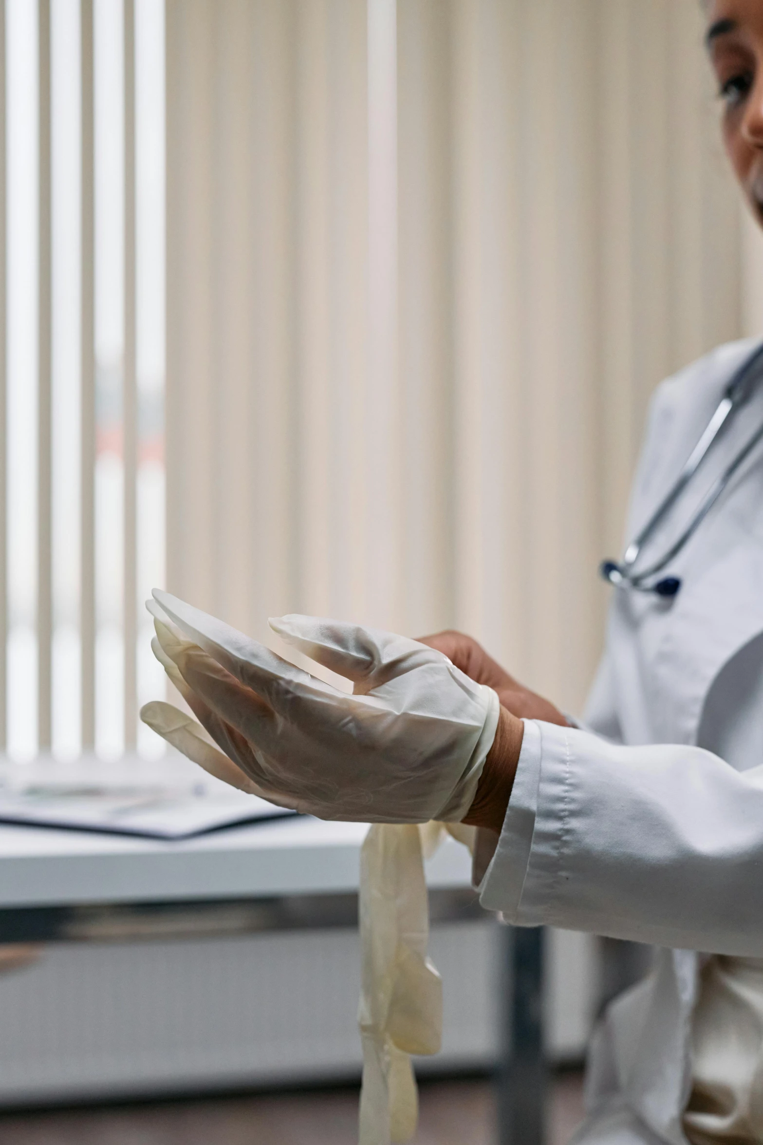 a woman in white coat wearing latex gloves holds soing