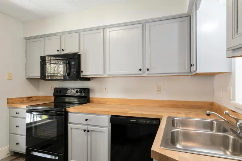 kitchen with black and silver appliances and white cabinets