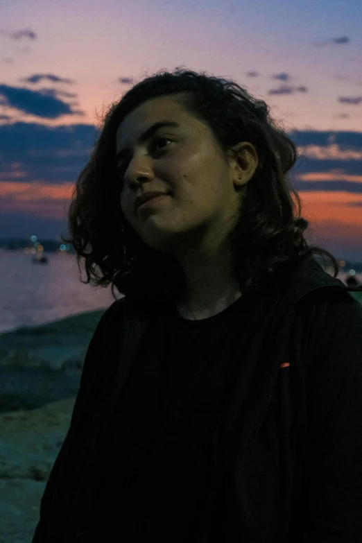 a woman looking back at the sky during sunset