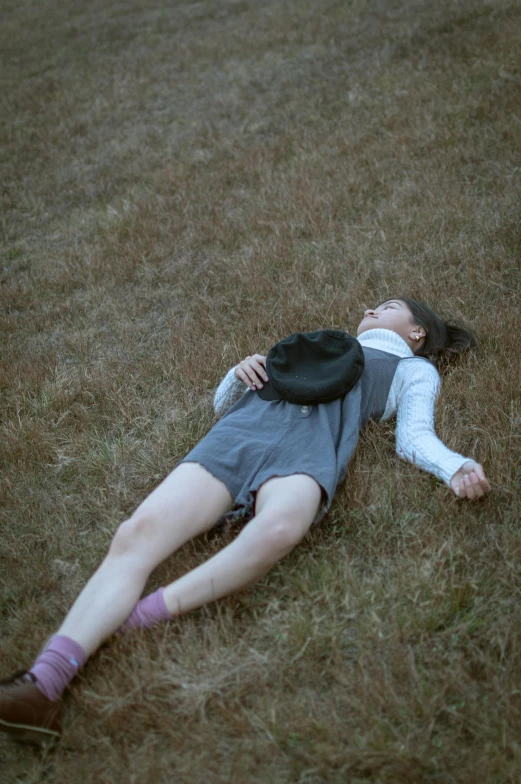 the woman is laying down in the grass