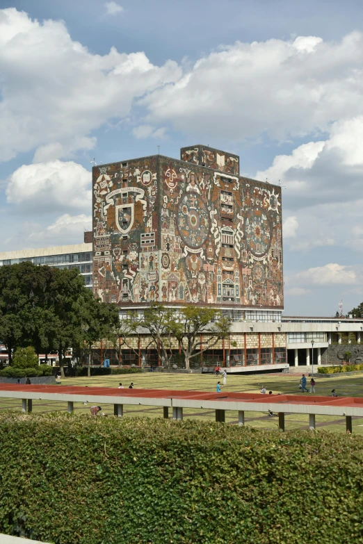 an intricate building with a hedge surrounding it