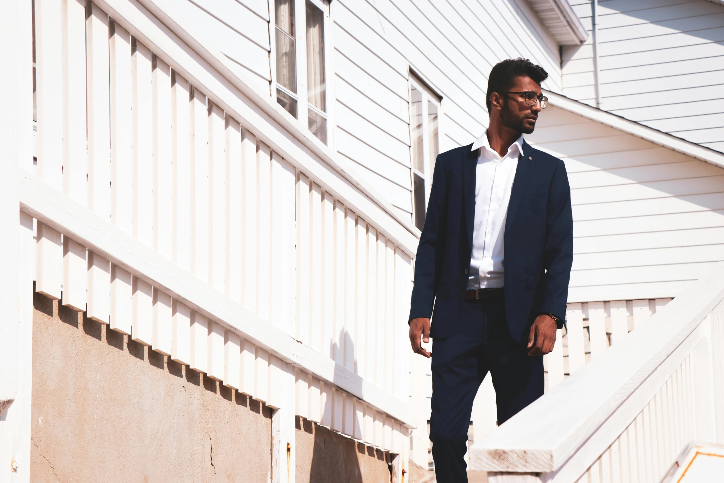 a man wearing a suit walks on steps