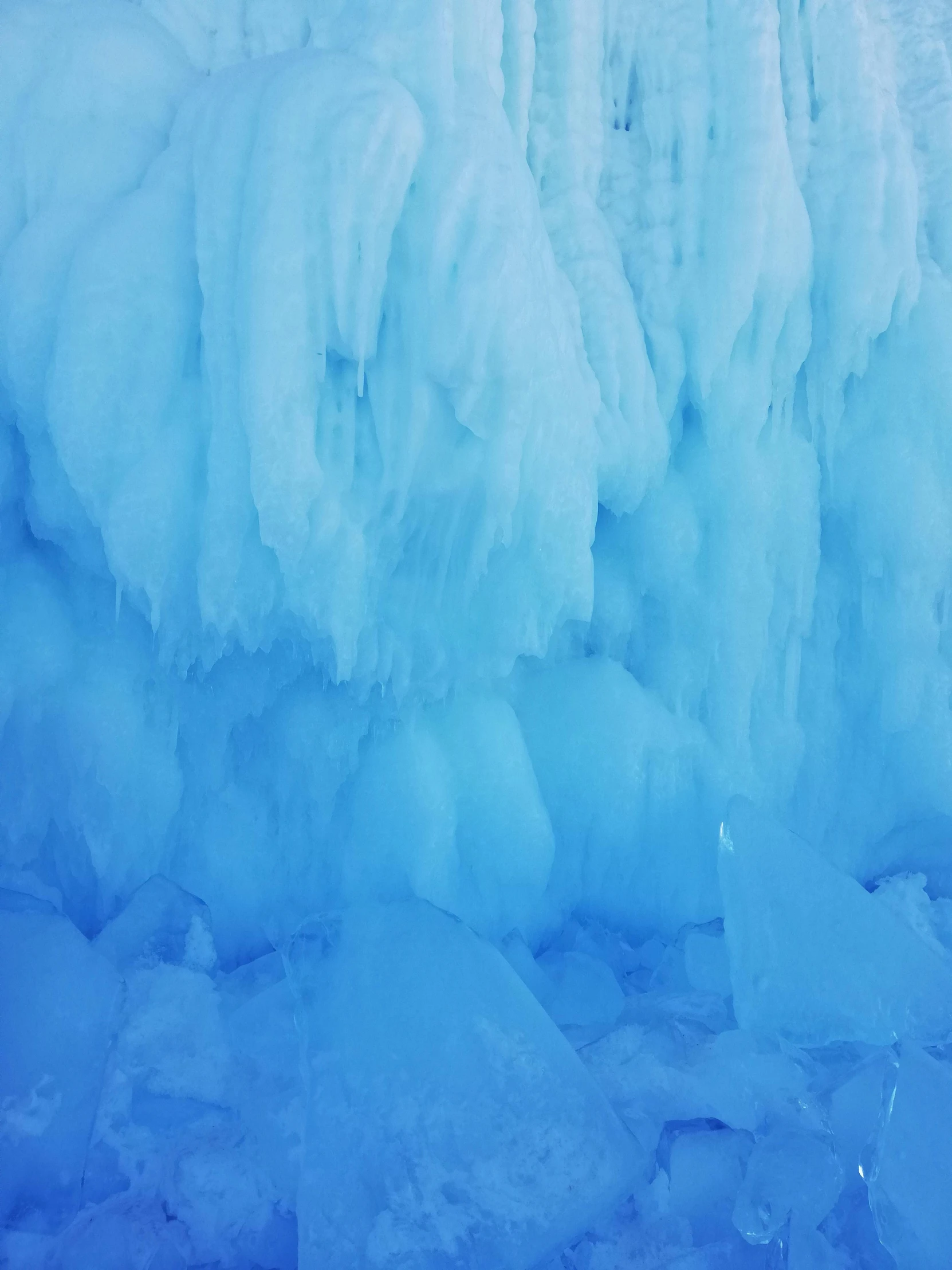 a man standing next to large ice wall