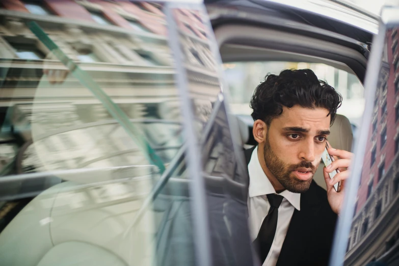 a man sitting in a car on the phone