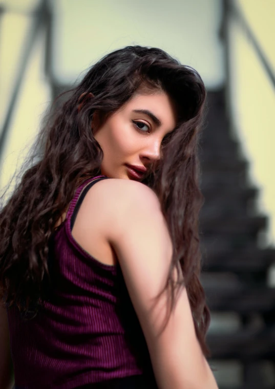 a woman with dark hair standing on stairs