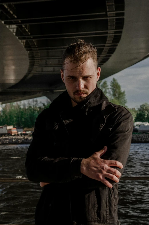 a man is standing under the bridge and posing