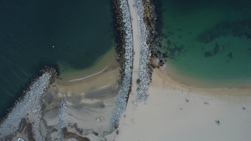 an overhead view of a sandy beach with rocks in it