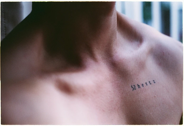 a man with a small ink writing on his chest