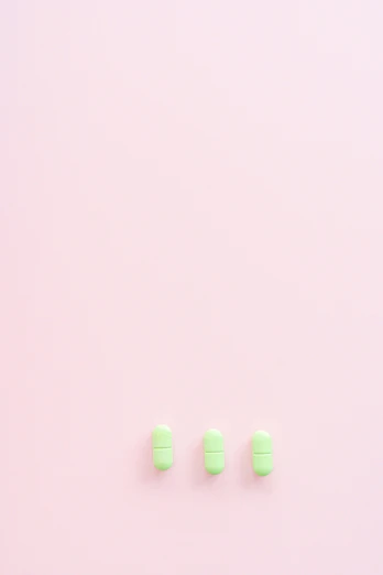 three pills with a light colored background