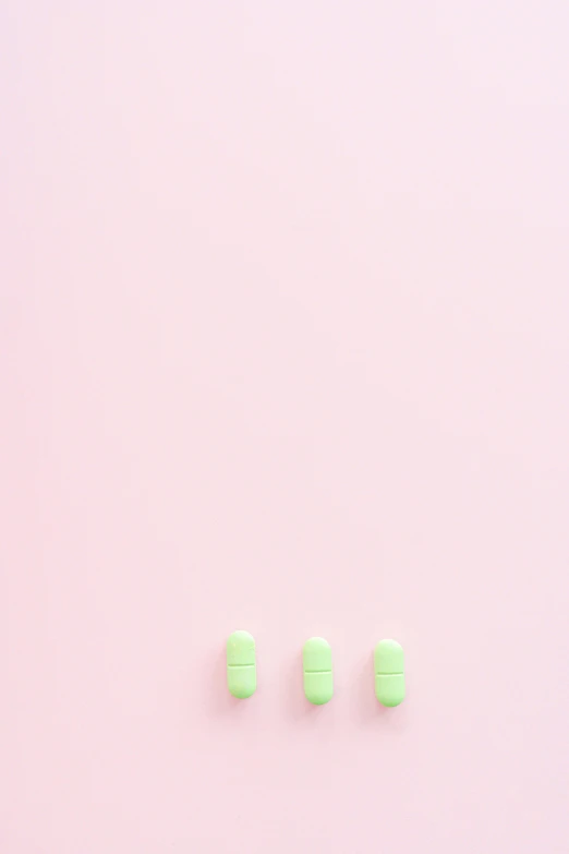 three pills with a light colored background