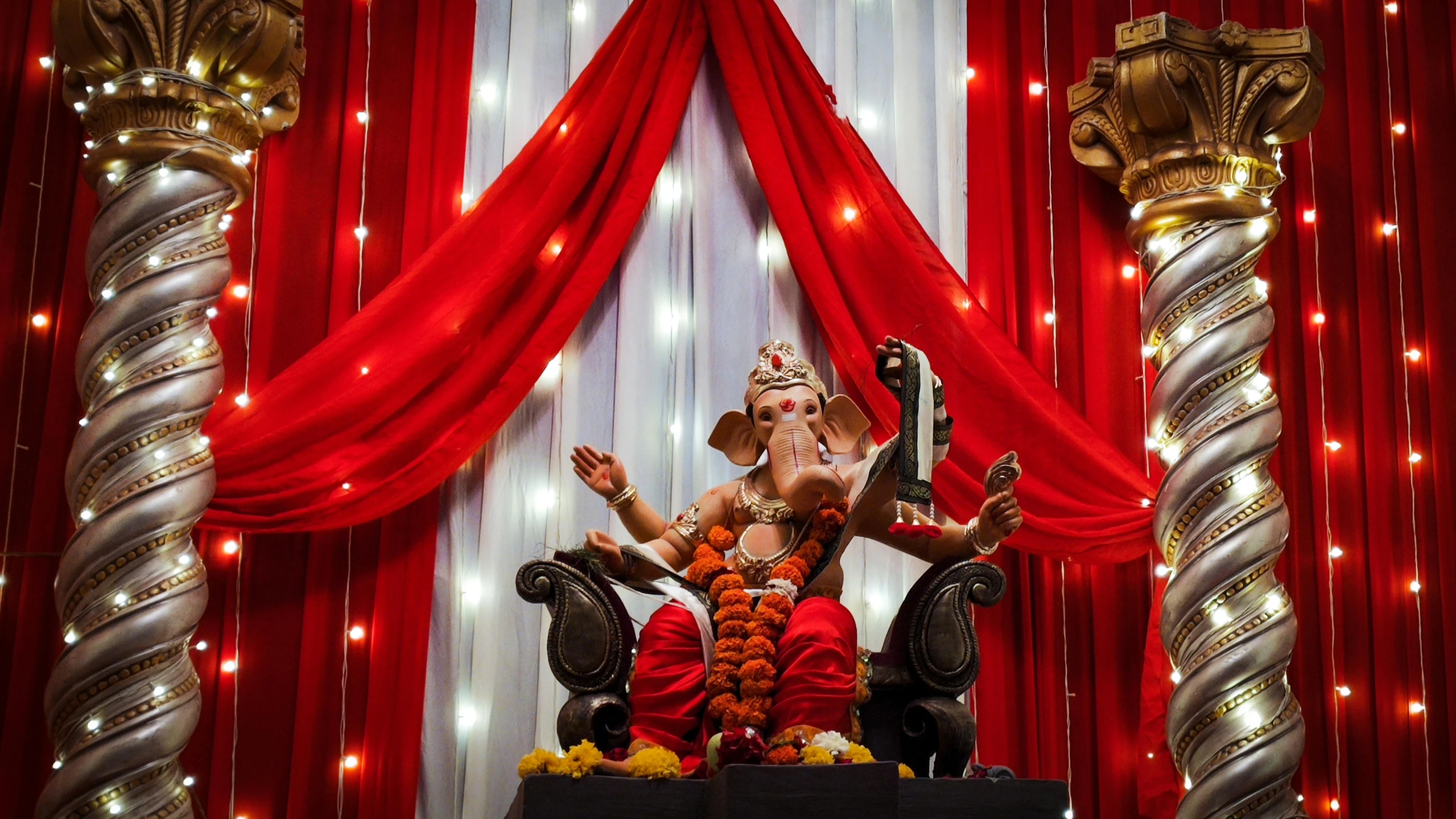 an indian shrine setting in the dark red curtains