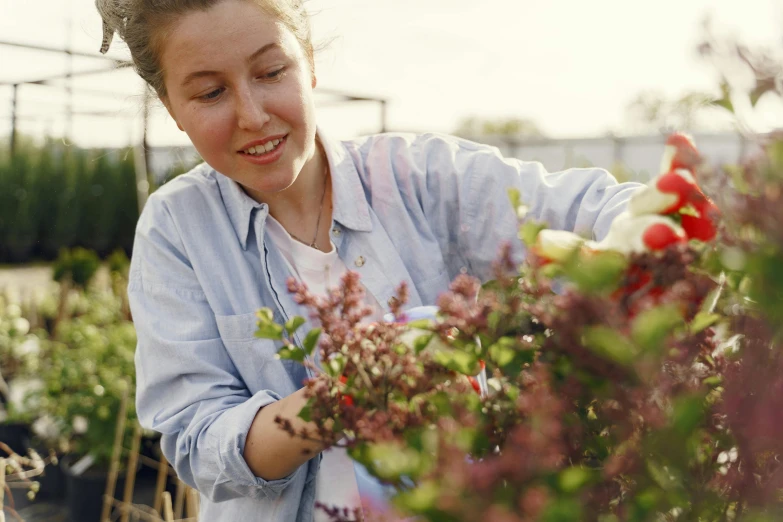 a woman smiling and holding flowers in a flower shop