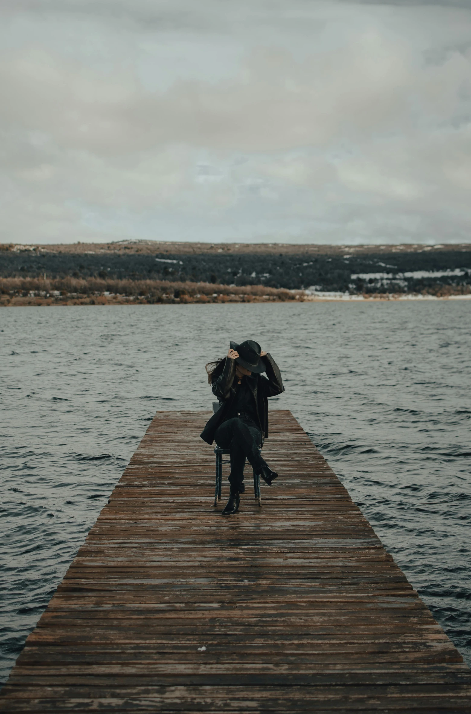 a person walking down a wooden dock towards water