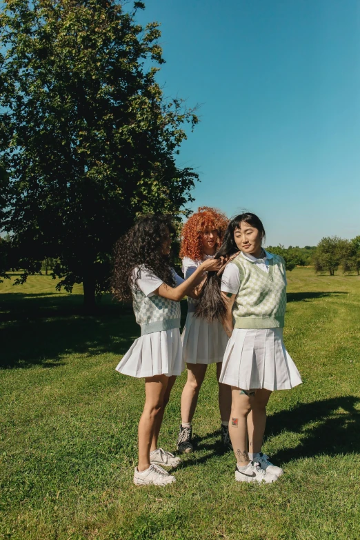 three girls in the park holding hands together