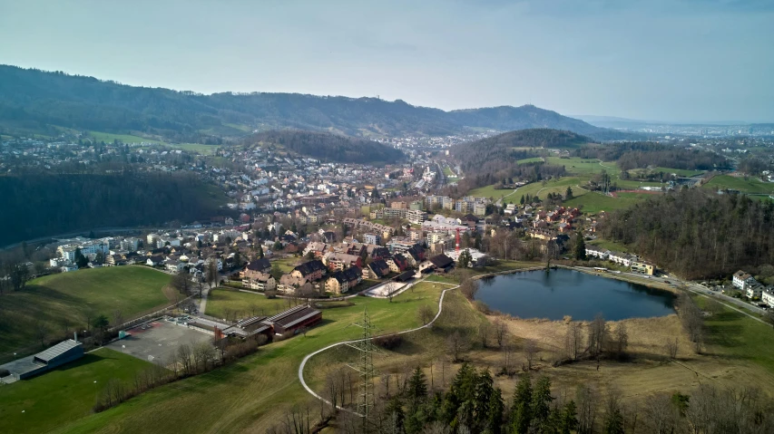 a large town surrounded by trees near a lake