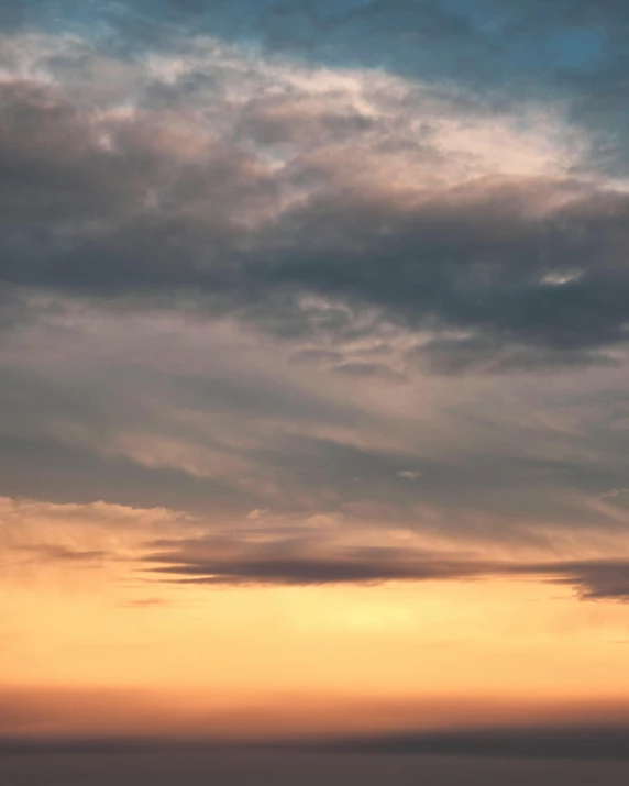 an airplane flying under a cloudy sky with a plane in the distance