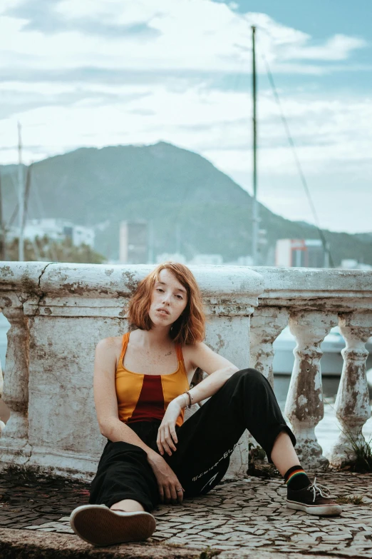 a woman sitting on the pavement next to the street